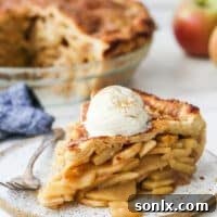 slice of mile high apple pie with ice cream on a plate