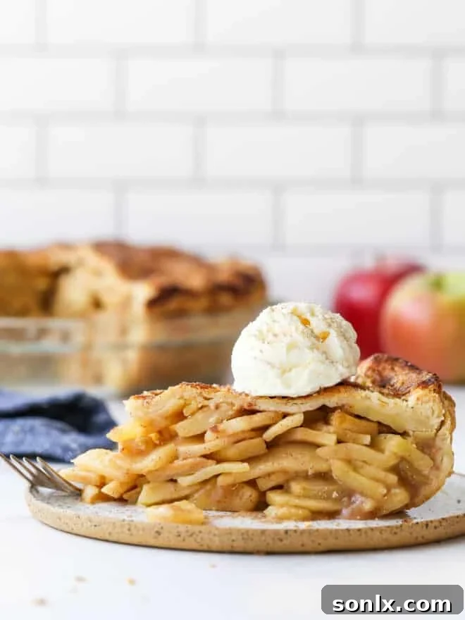 slice of mile high apple pie on a plate with pie in background