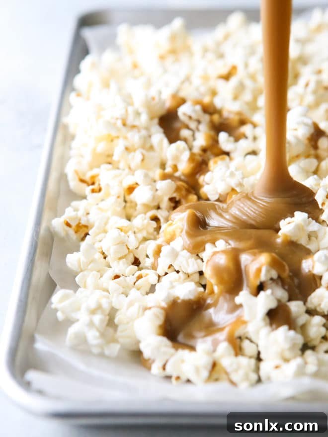 pouring caramel sauce over popped popcorn