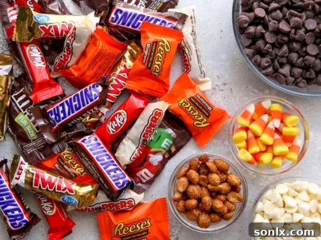 Various ingredients laid out for Halloween candy bark, including chocolate, nuts, and assorted candies.