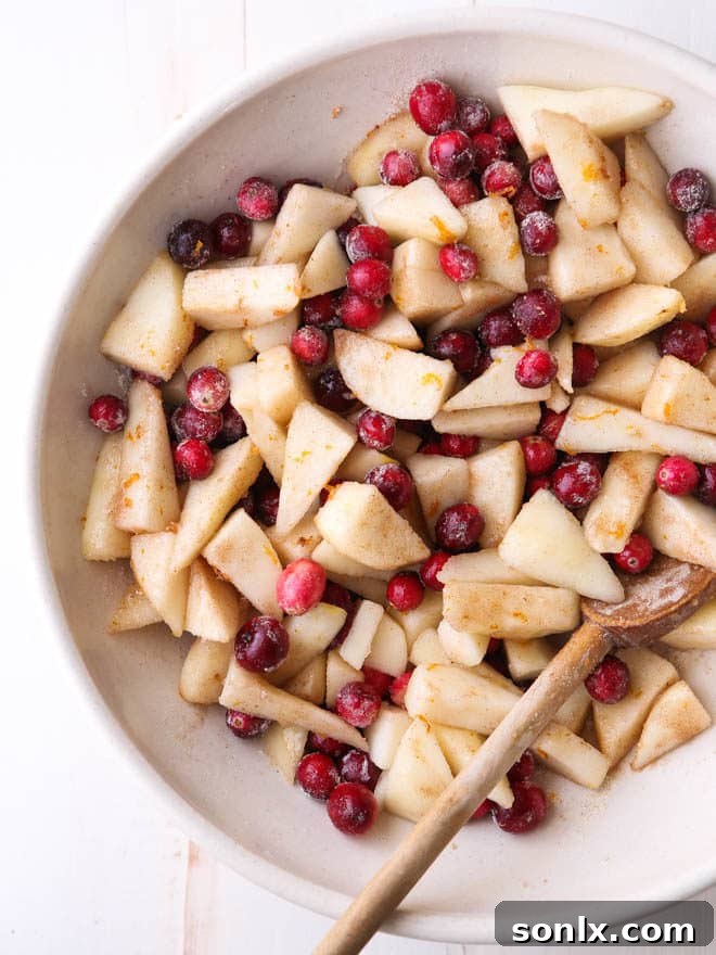 A festive Cranberry Pear Pie ready for baking, showcasing its beautiful crimped crust and promising a delicious fall dessert.