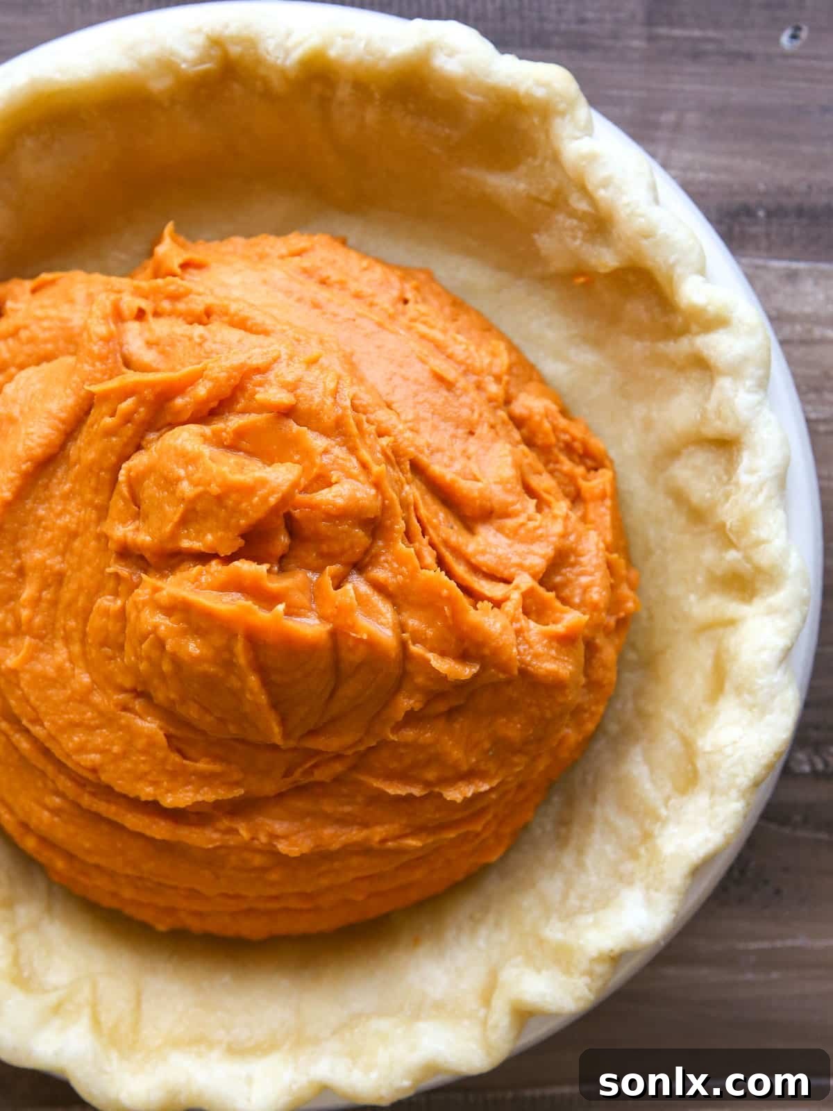 poured sweet potato filling inside par baked pie crust