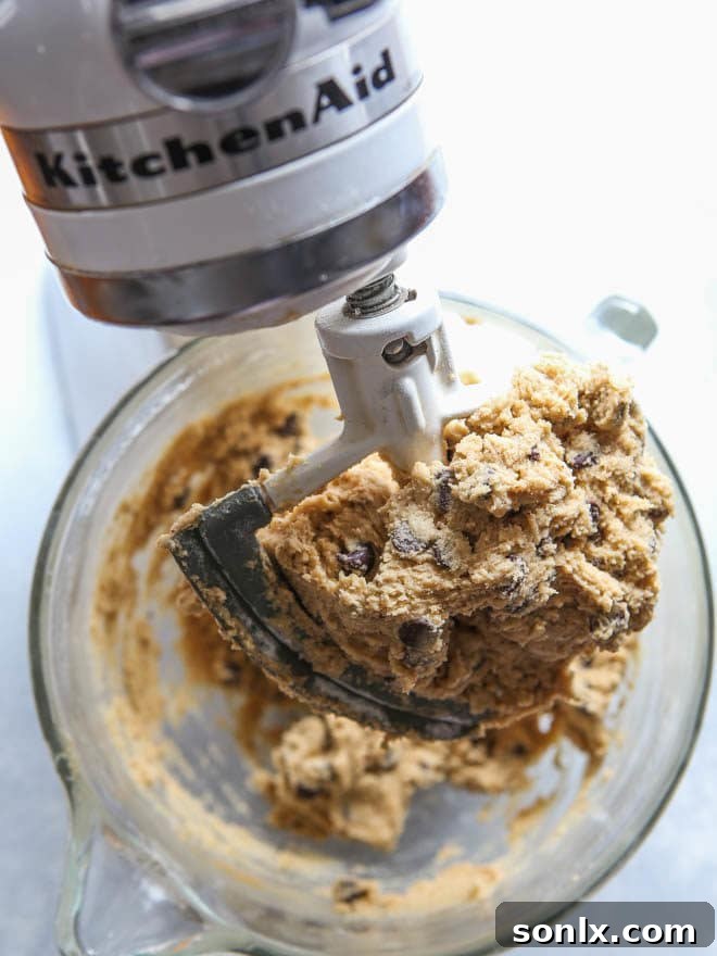 How to bake perfectly pretty cookies on completelydelicious.com. A batch of freshly baked brown butter chocolate chip cookies on a wire rack.