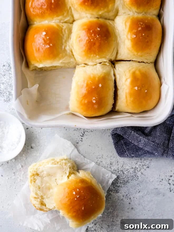 soft white dinner rolls in pan and sliced with butter, showing their fluffy texture