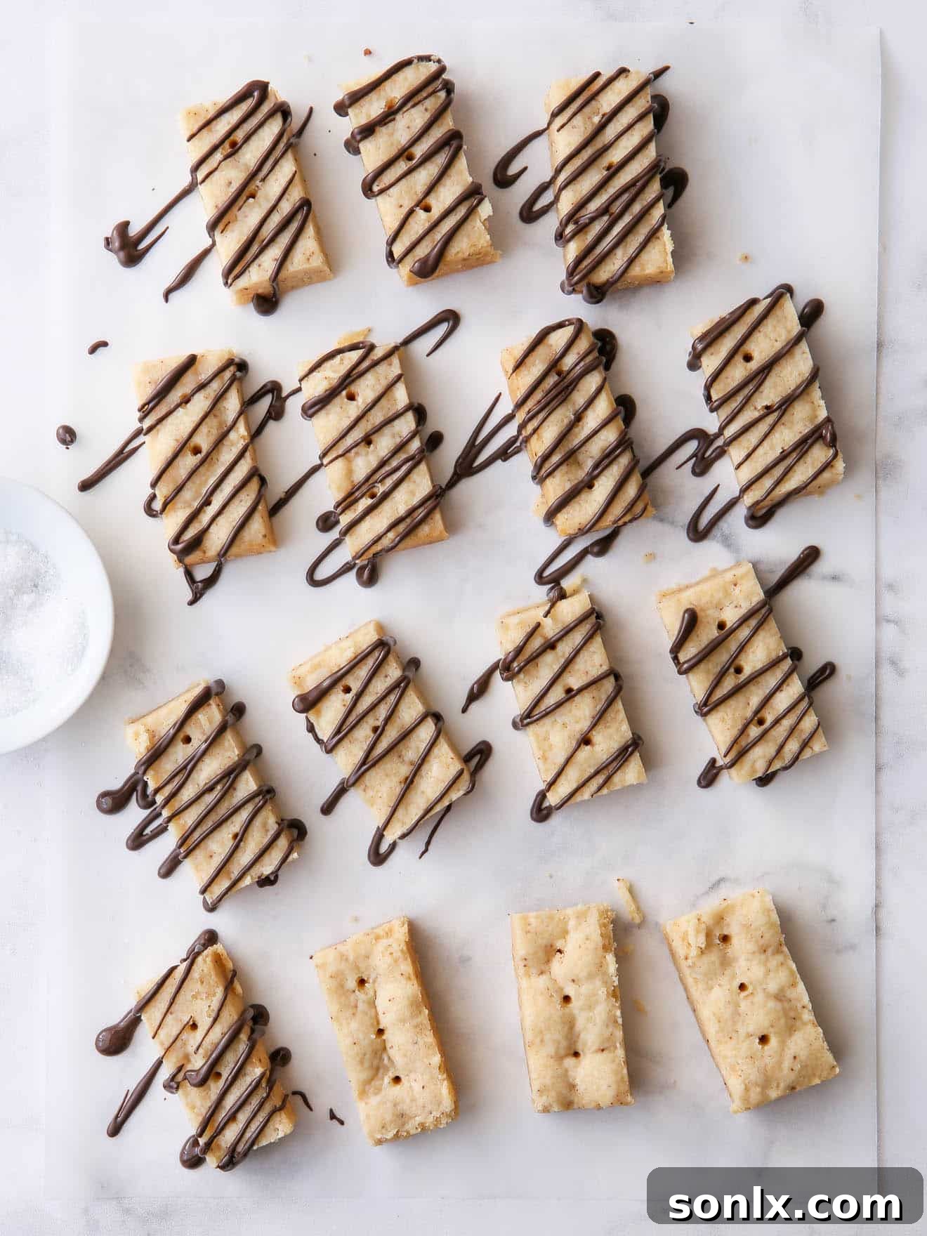 brown butter shortbread cookies on parchment with chocolate drizzle, ready for serving