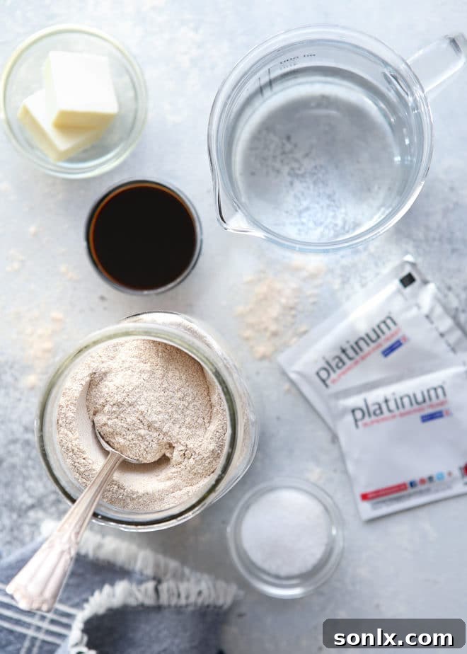 A close-up shot of the simple ingredients laid out for making 100% whole wheat bread, including flour, butter, molasses, yeast, and salt.