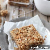 Delicious homemade Coconut Oatmeal Bars stacked on a white plate.