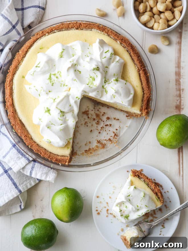 A slice of Tequila Key Lime Pie on a plate, showing its creamy texture and crumbly macadamia nut crust.