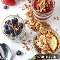 A beautifully layered granola yogurt parfait with fresh berries in a glass jar