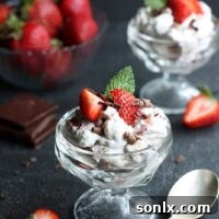 Chocolate Eton Mess in a glass dish, garnished with fresh strawberries