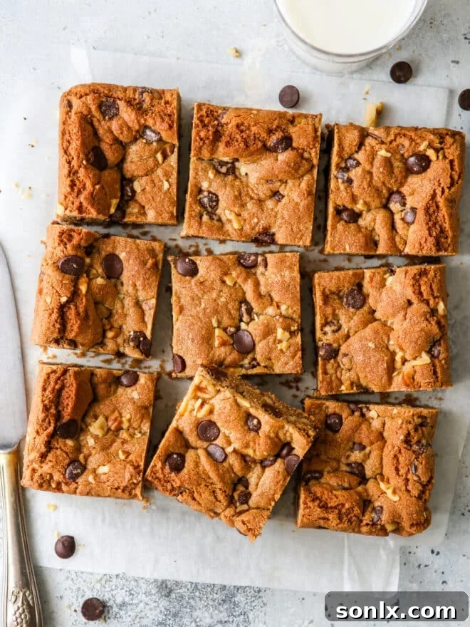 Sliced whole wheat chocolate chip cookie bars with a glass of milk, showcasing their chewy texture and chocolate chunks.