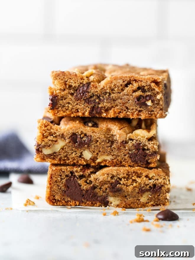 Baked whole wheat chocolate chip cookie bars stacked neatly, ready to be served.