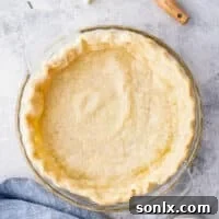 A perfectly blind-baked pie crust on linen, ready to be filled, demonstrating success.