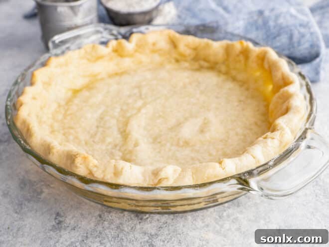A magnificent, fully blind-baked pie crust, golden and inviting, ready to become the base of a spectacular pie.