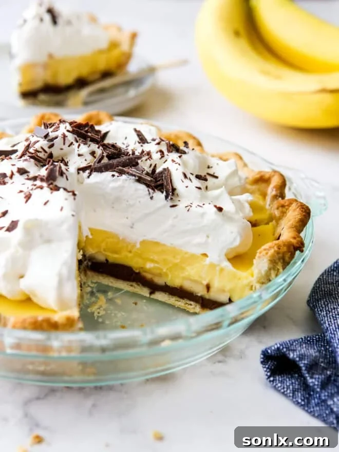 A delectable chocolate banana cream pie, with a slice removed to reveal layers of rich chocolate, fresh bananas, and fluffy cream.