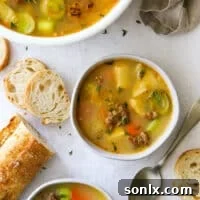 potato leek and italian sausage soup in bowls with crusty bread