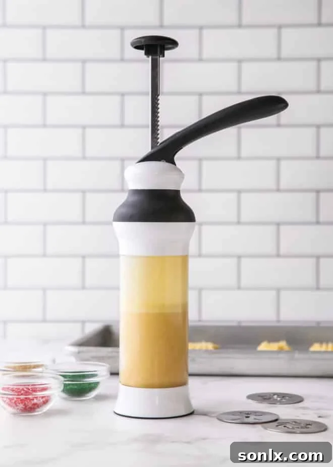 A cookie press filled with smooth, ready-to-use spritz cookie dough, poised for creating festive shapes.