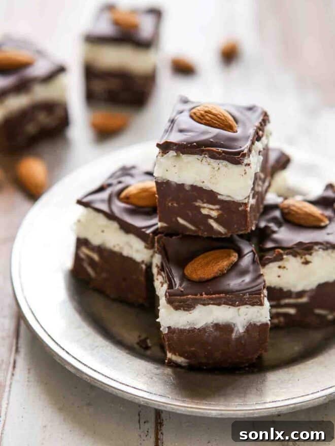Stack of luscious coconut almond fudge squares on a plate, ready to be enjoyed.