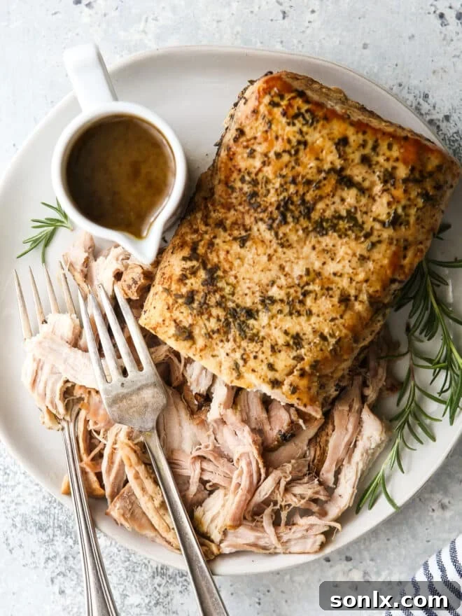 slow cooker rosemary balsamic pork roast shredded on a plate