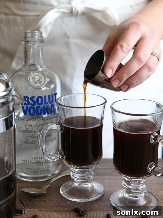 Pouring Absolut Vodka into the coffee for the White Russian Mocha cocktail.
