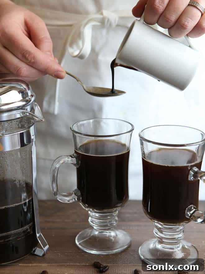 Adding coffee liqueur and chocolate syrup to the White Russian Mocha mixture.