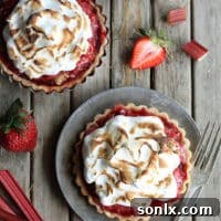 Beautifully plated Strawberry Rhubarb Meringue Tartlets, showcasing the toasted meringue topping and fruit filling