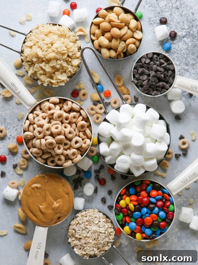 Stacked Monster Marshmallow Cereal Treats on a parchment-lined tray, highlighting their vibrant colors and generous mix-ins.