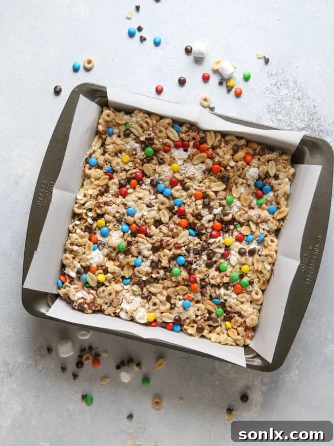 The Monster Marshmallow Cereal Treat mixture pressed into a baking pan, showing a rich, dense texture before cooling.