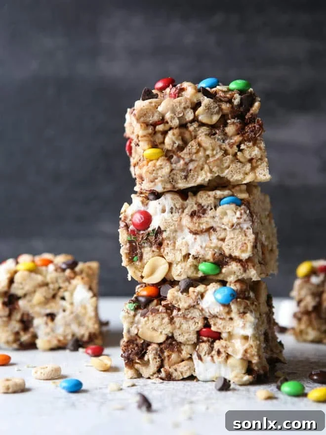 A plate of freshly cut Monster Marshmallow Cereal Treats, ready to be enjoyed, showing their vibrant mix-ins.