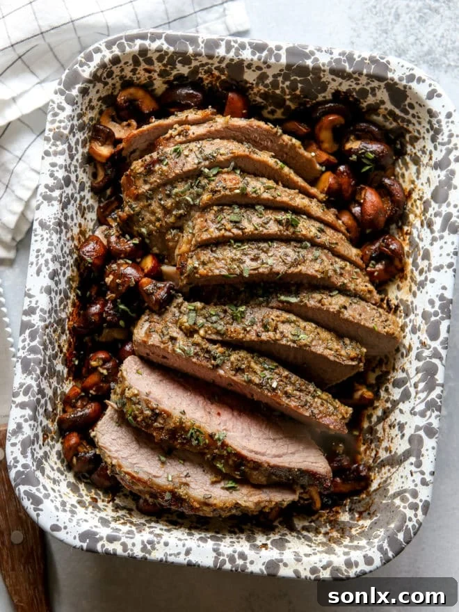 garlic and herb tri-tip roast with mushrooms sliced in baking dish