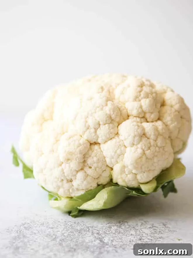 A close-up of cauliflower florets coated in tempura batter before frying.