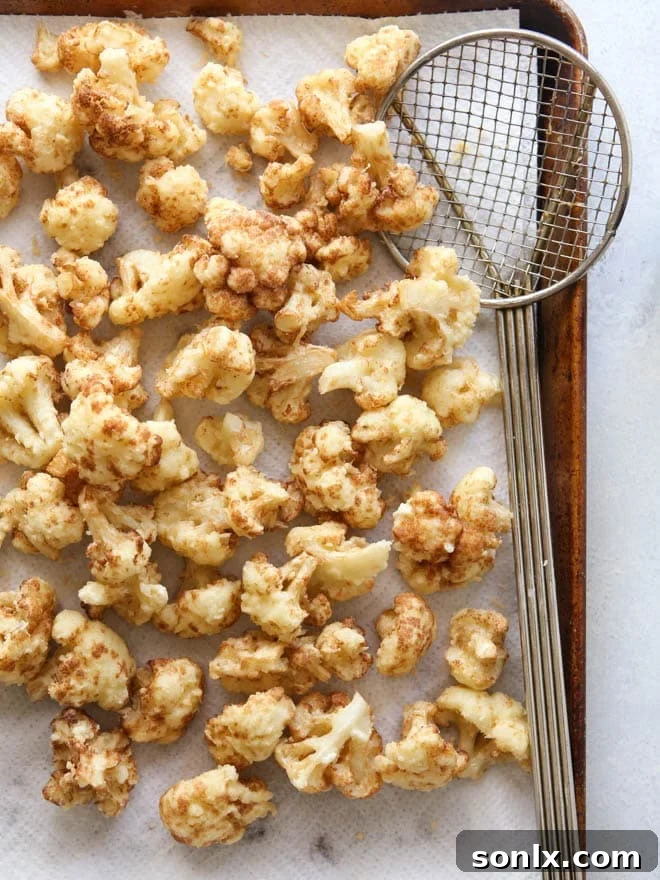 Crispy tempura cauliflower with a bowl of creamy spiced yogurt dipping sauce.