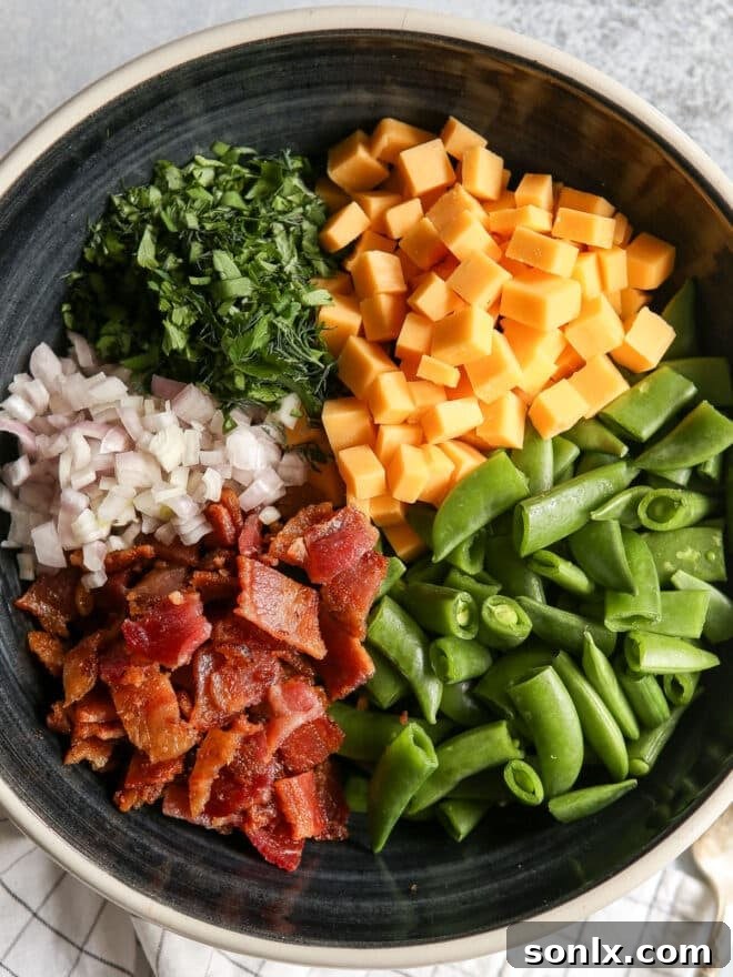 All ingredients for the sugar snap pea salad in a bowl, before mixing