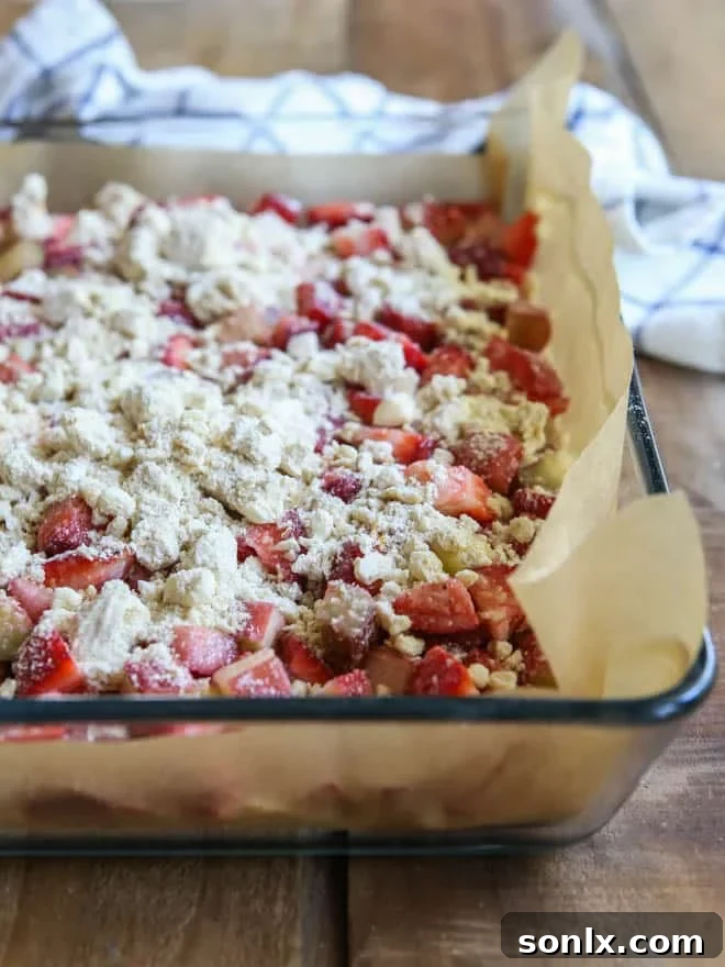 A tray of freshly baked strawberry rhubarb crumb bars, ready to be sliced
