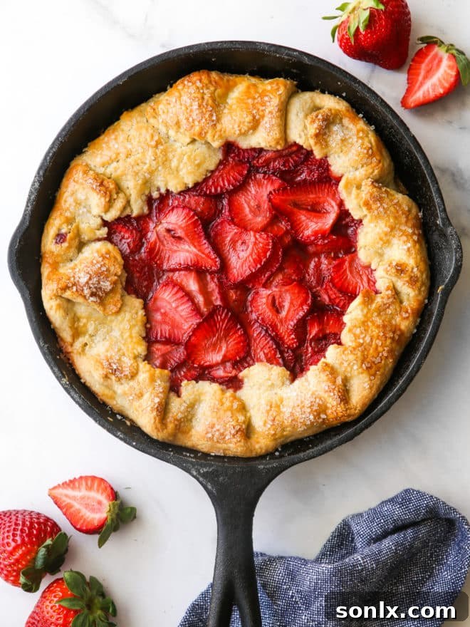 A perfectly baked strawberry skillet pie, featuring a golden, crisp crust and a beautifully bubbling, caramelized strawberry filling, fresh out of the oven.