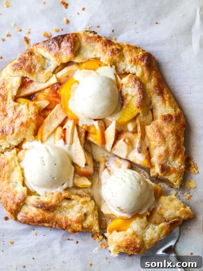 Rustic Orchard Peach Apple Galette 2 Sliced Peach Apple Galette topped with vanilla ice cream, showcasing its golden crust and fruity filling