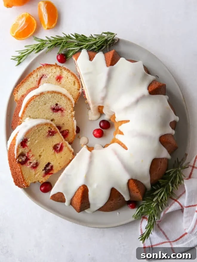 cranberry orange bundt cake and slices arranged beautifully on a plate