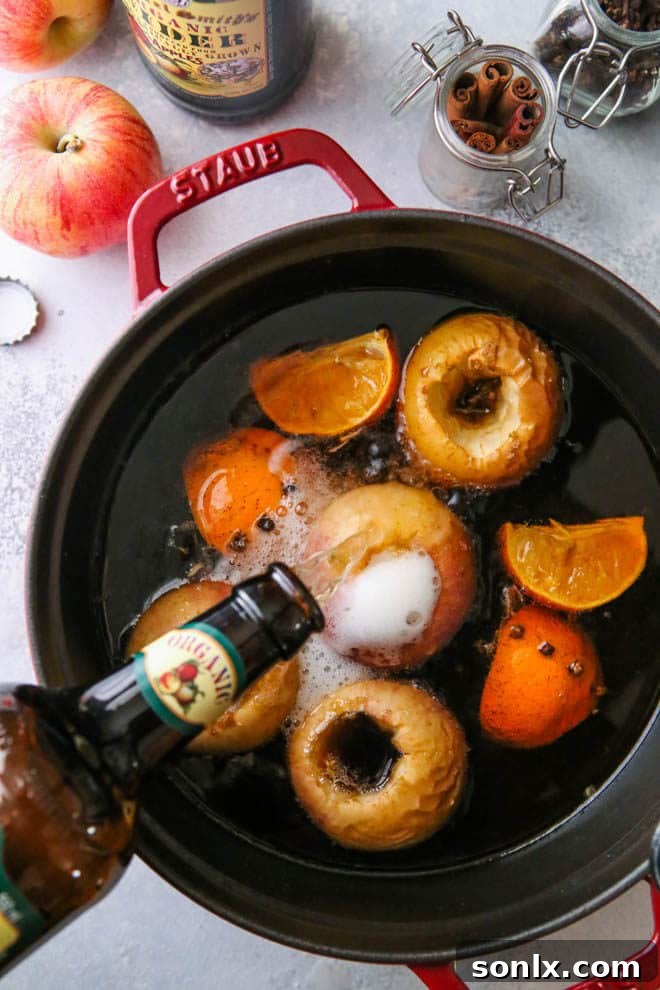 Wassail ingredients, including sliced oranges, lemon, cinnamon sticks, and whole cloves, arranged artfully.