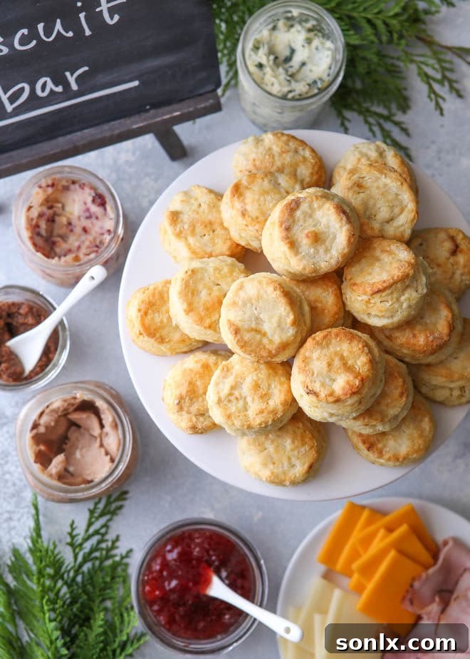 Host a Holiday Biscuit Bar with Cream Cheese Biscuits 5 An overhead view of a beautifully set holiday biscuit bar, featuring cream cheese biscuits and an array of sweet and savory toppings presented in charming mismatched dishes.