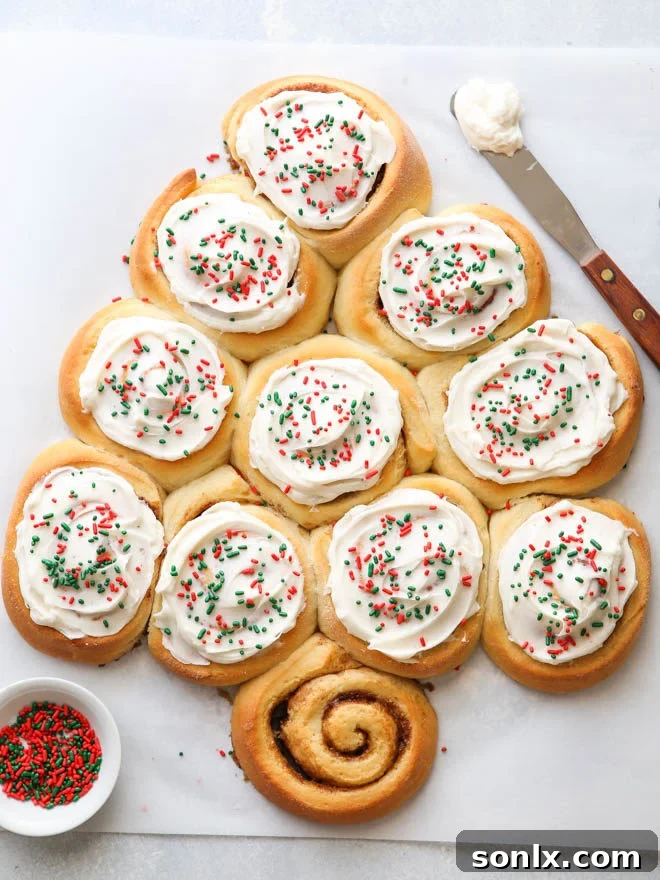 A beautifully decorated cinnamon roll Christmas tree, perfect for a festive holiday breakfast.