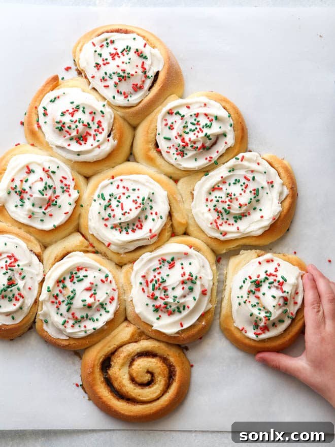 Overhead shot of the finished cinnamon roll Christmas tree with frosting and sprinkles, ready to serve.