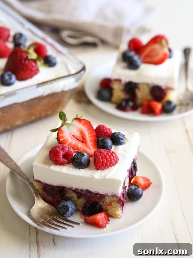 Homemade Berry Poke Cake with fresh fruit and real whipped cream, ideal for summer
