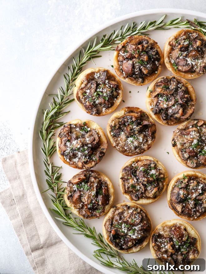 Easy mini mushroom tarts made with puff pastry, Parmesan, and rosemary