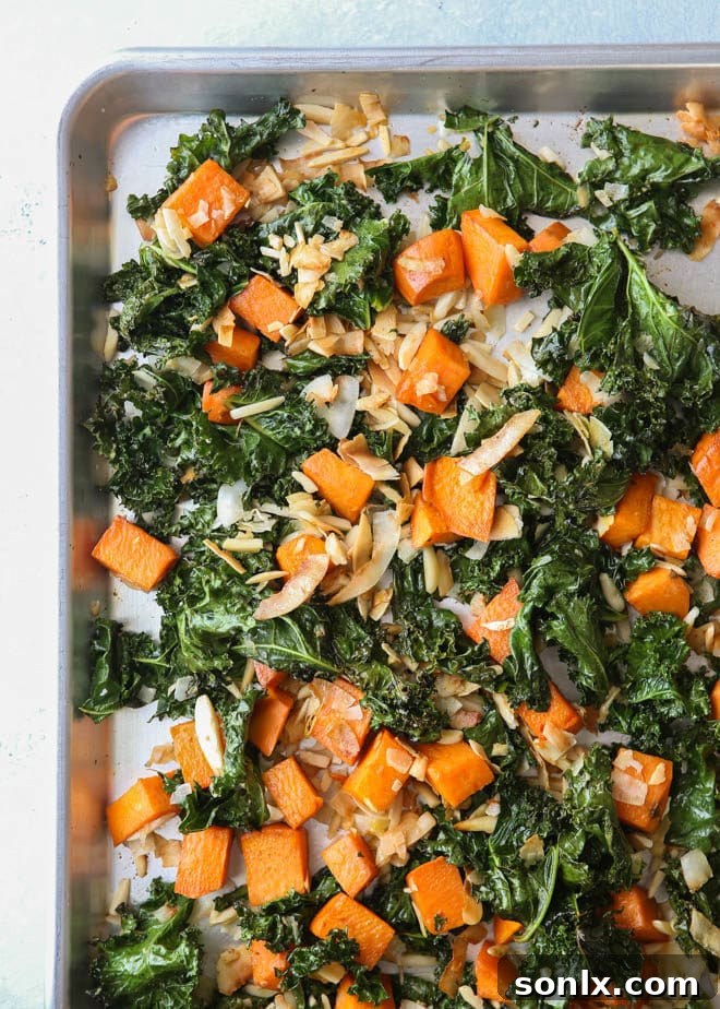 Close-up of perfectly roasted sweet potatoes and tender kale, mixed with toasted shredded coconut and slivered almonds, ready to be added to the farro bowl.