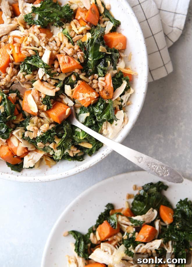 A beautifully composed farro bowl with chicken, kale, and sweet potatoes, showcasing all the vibrant ingredients and delicious dressing, ready to be enjoyed as a healthy and satisfying meal.