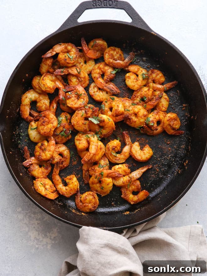 Overhead view of several Mumbai Spiced Shrimp Tacos lined up, ready to be served