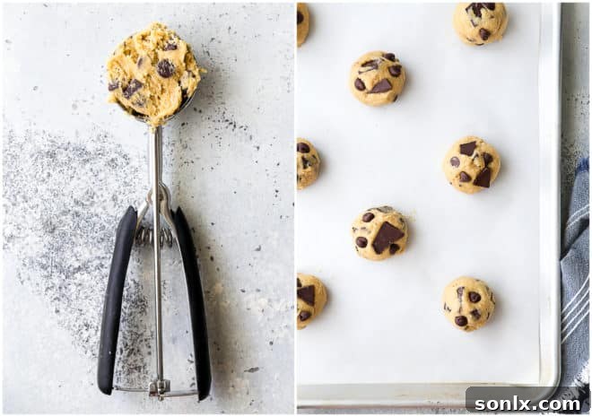 A hand using a spring-loaded scoop to portion chocolate chip cookie dough onto a baking sheet, ensuring uniform size