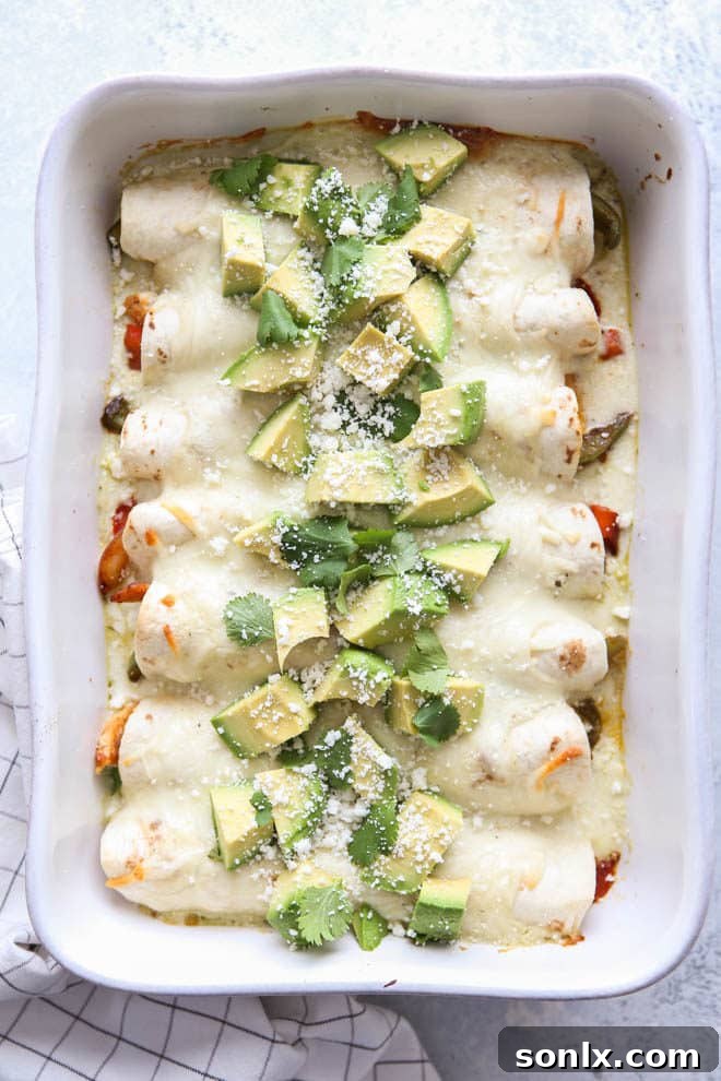 Close-up of a single chicken fajita enchilada, showcasing the melted mozzarella cheese and creamy sauce, garnished with fresh cilantro.