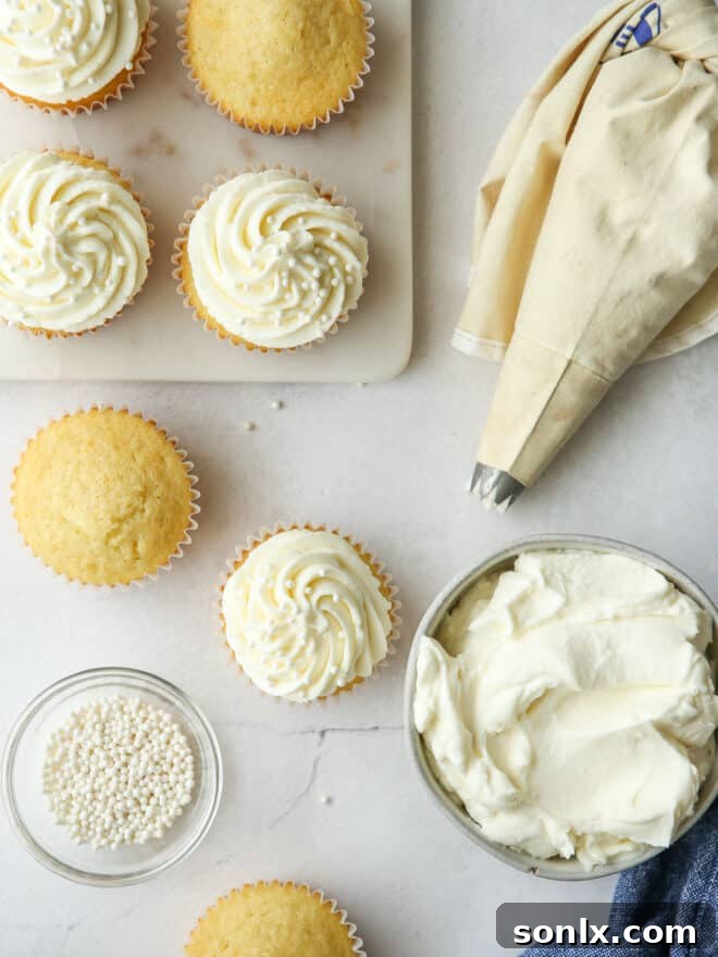 A beautifully frosted vanilla cupcake topped with colorful sprinkles, ready to be enjoyed.