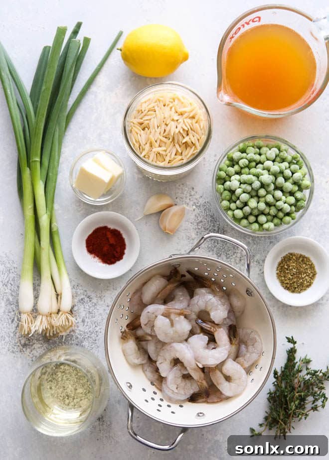 Fresh ingredients laid out on a kitchen counter for making shrimp and pea orzo, including shrimp, orzo, lemons, and herbs.